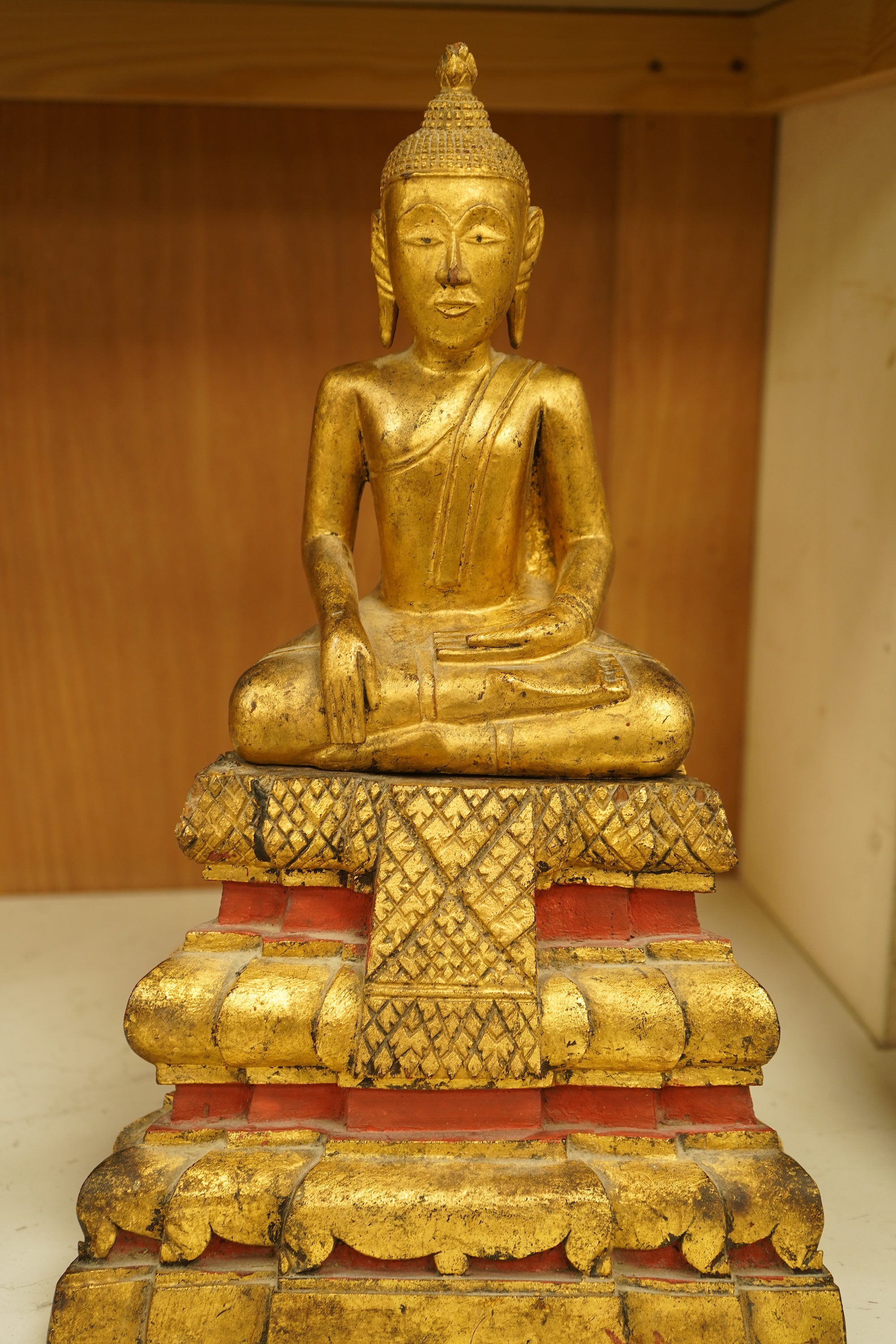 A 19th century Burmese giltwood figure of seated Buddha, 40cm high